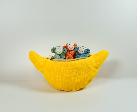 A yellow zippered fabric banana toy with three colorful mini stuffed animals inside.