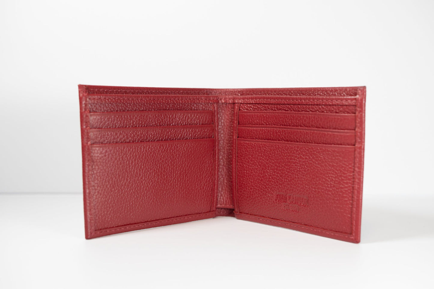 A red slim bifold leather wallet open to show multiple card slots and a full-length bill compartment.
