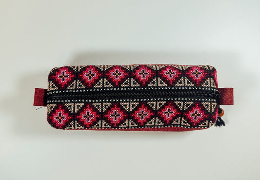 A vibrant Thai Tribal Pencil case with a geometric pattern and a metal zipper.