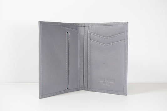 A gray slim vertical pocket wallet made from eco-conscious certified full-grain leather, featuring multiple card slots and a coin pocket.