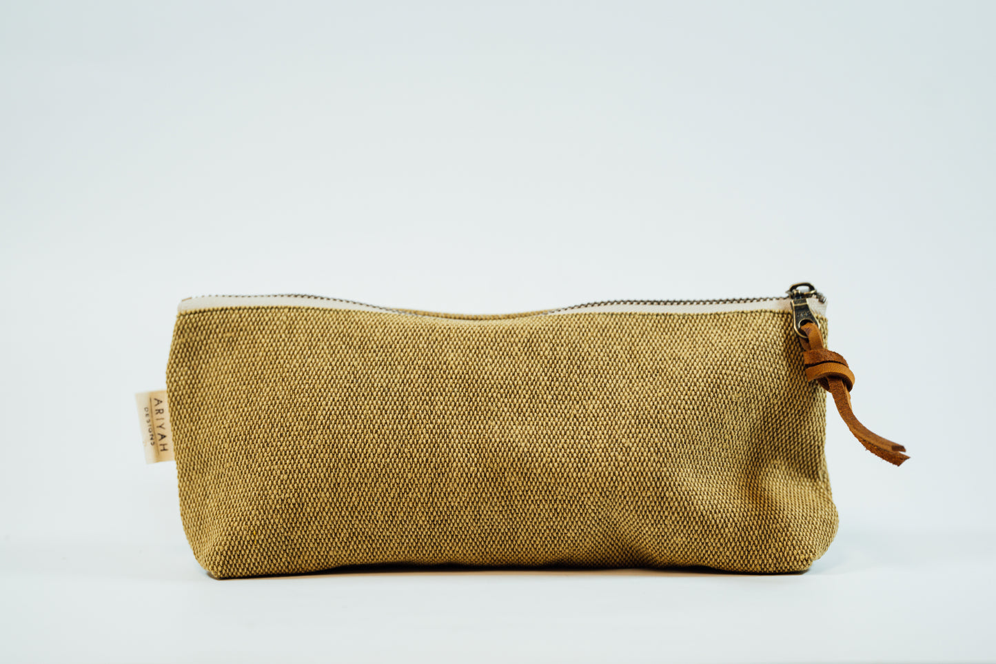 A green fabric pencil case with a metal zipper and a leather tassel, against a white background.