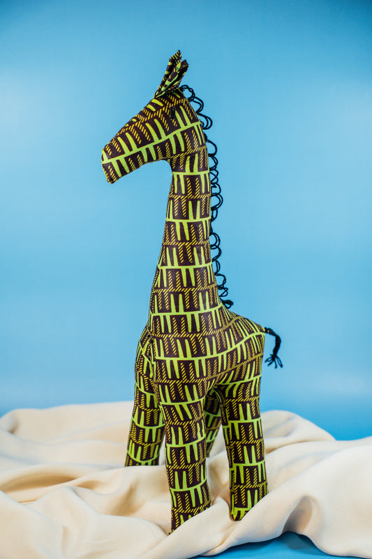 A handcrafted giraffe made from vibrant African fabric, displayed against a blue background.