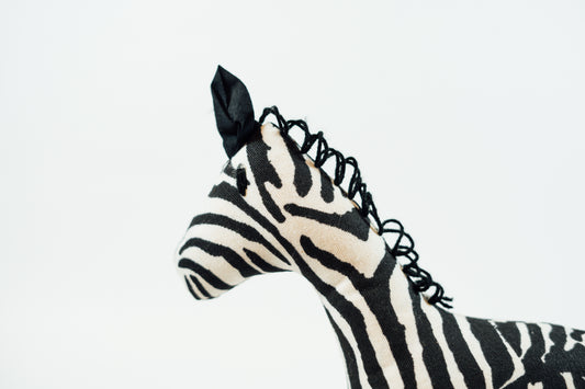 Close up of the head of a zebra stuffed animal made in Uganda