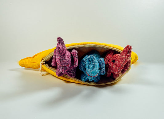 A yellow zippered fabric banana toy with three colorful mini stuffed animals inside.