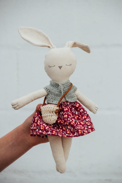 A Bunny Stuffed animal wearing a red floral skirt and green crocheted top from Hope's Gate