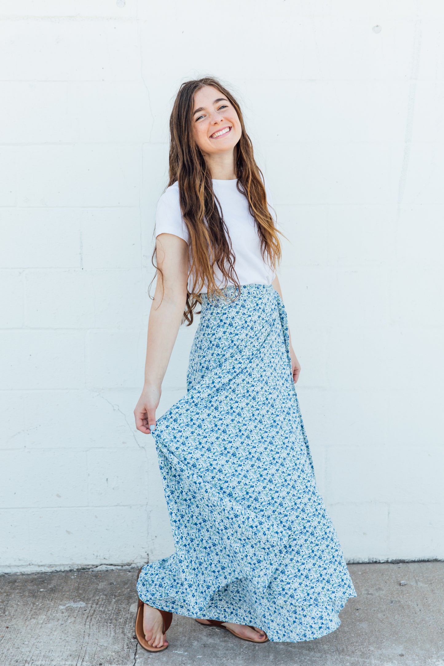 A woman wearing a blue floral maxi wrap skirts.