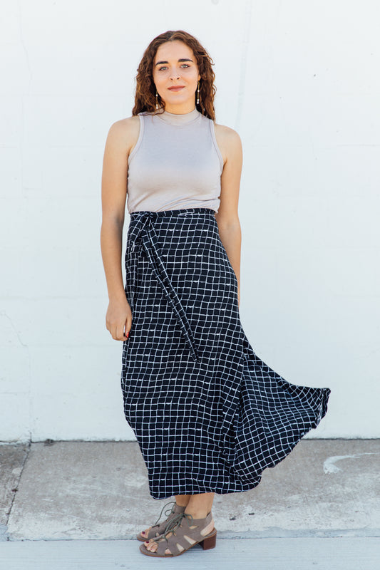 A women wearing black checkered maxi wrap skirt.