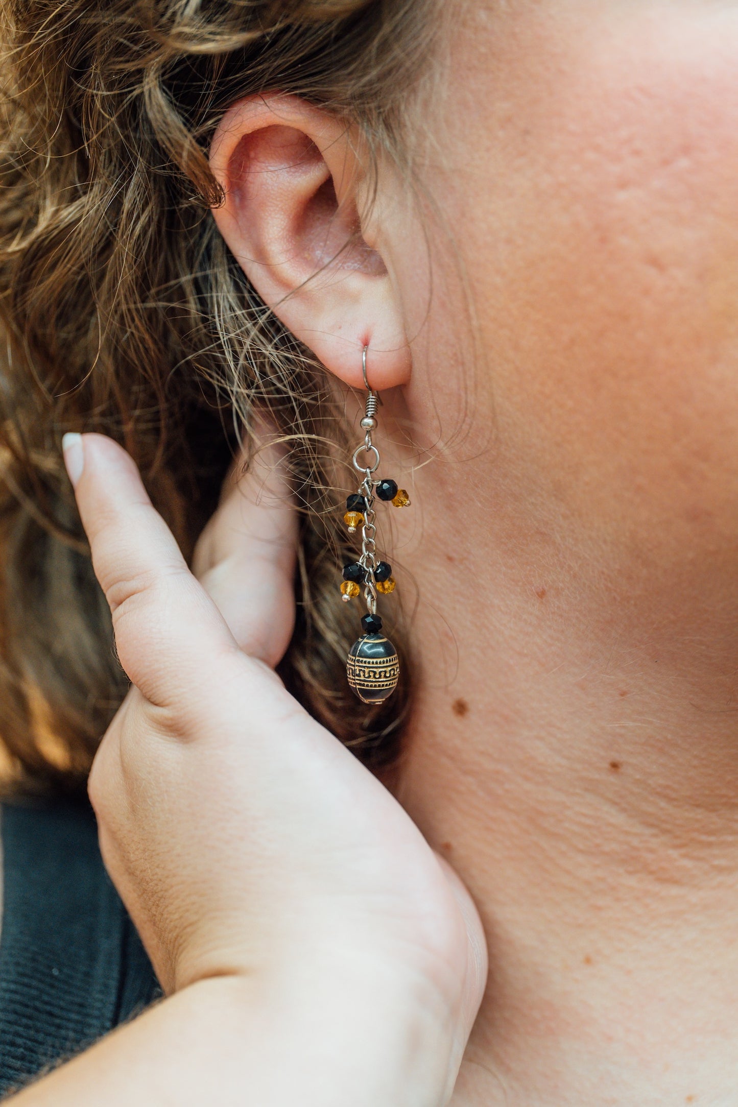 Close-up of an earring being worn with a blurred background