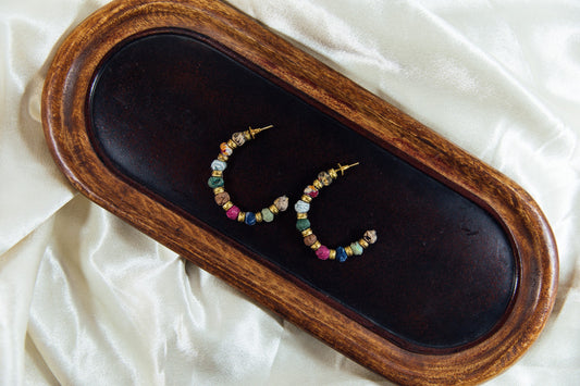 Large hoop earring with multicolored fabric beads.
