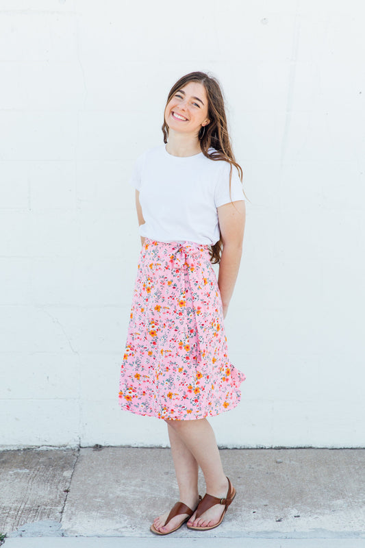 A woman wearing a pink floral midi wrap skirt