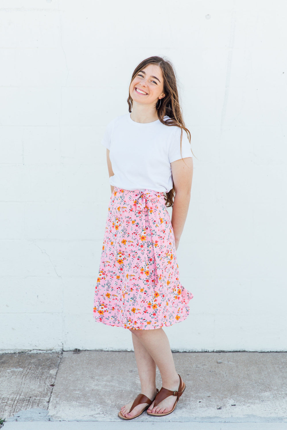 A woman wearing a pink floral midi wrap skirt