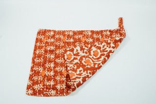 A hand-stitched red and white block-print hand towel with a loop for hanging.