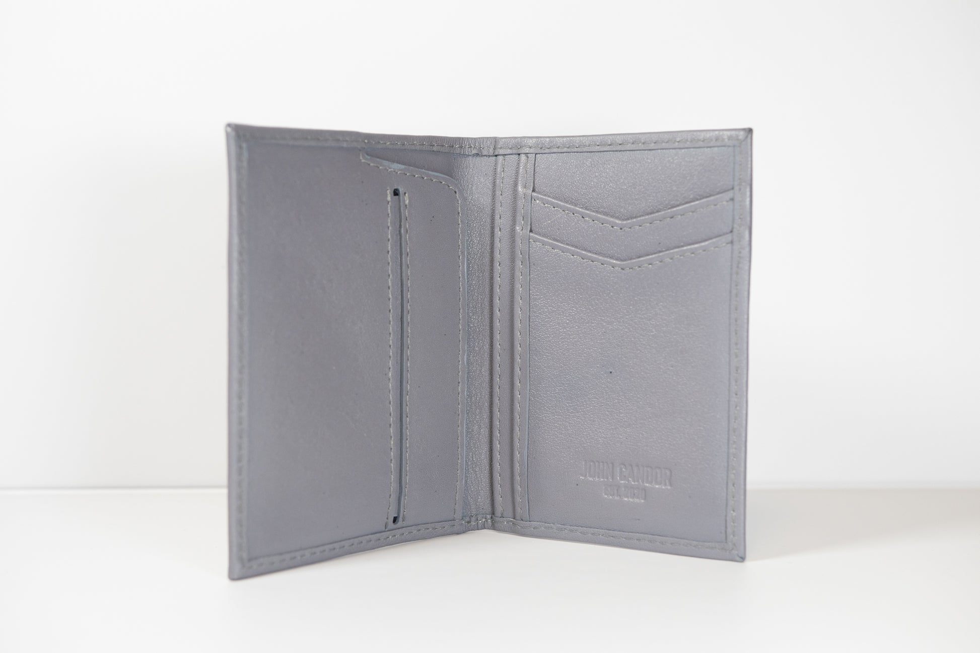 A gray slim vertical pocket wallet made from eco-conscious certified full-grain leather, featuring multiple card slots and a coin pocket.