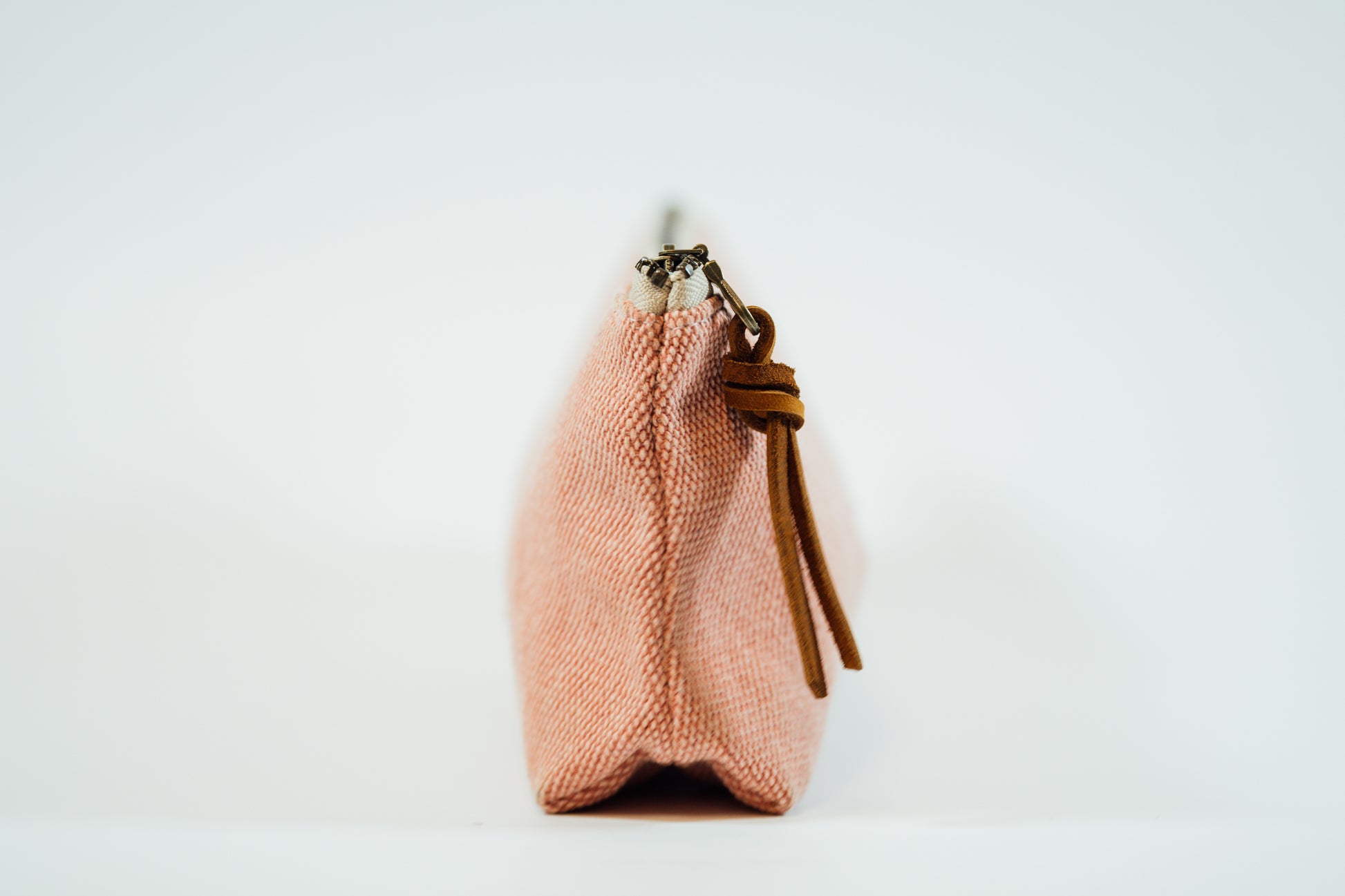 The side view of a pink fabric pencil case 